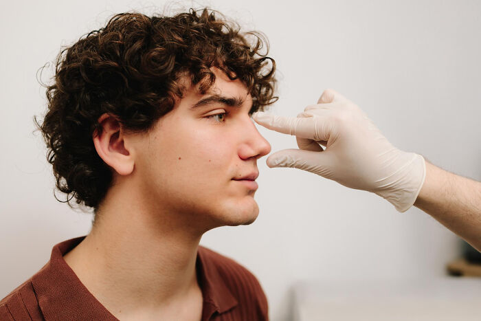 Man undergoing nose examination by healthcare professional