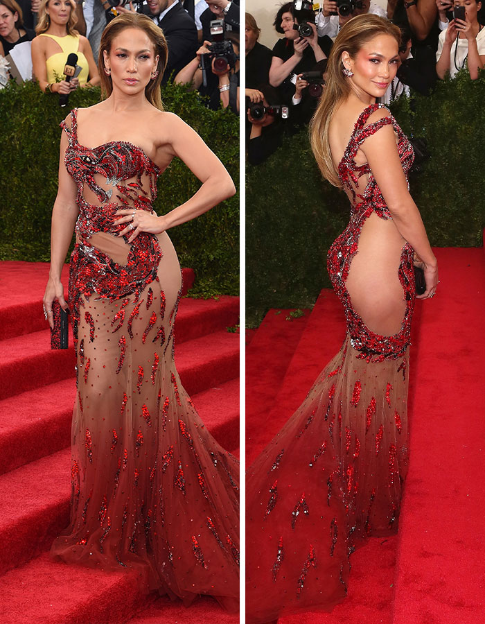 Jennifer Lopez in a bold sheer outfit on the MET Gala red carpet, showcasing a daring red embellished gown.