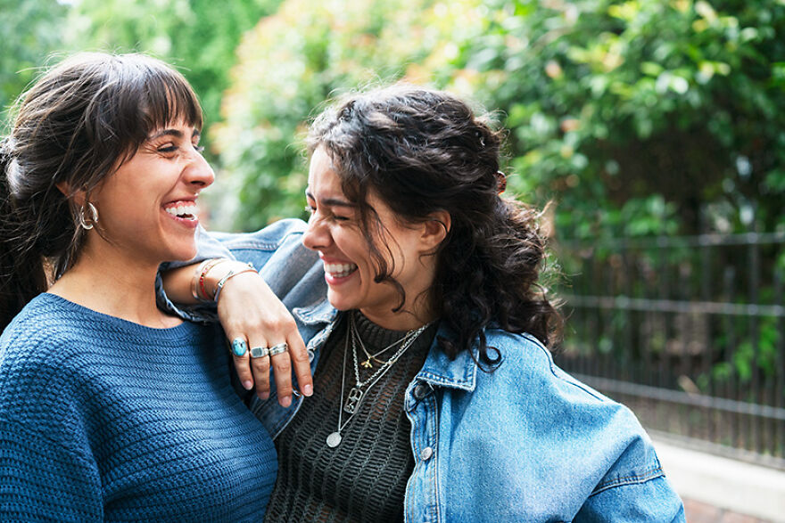 Two women laughing and enjoying a mood boost together outdoors