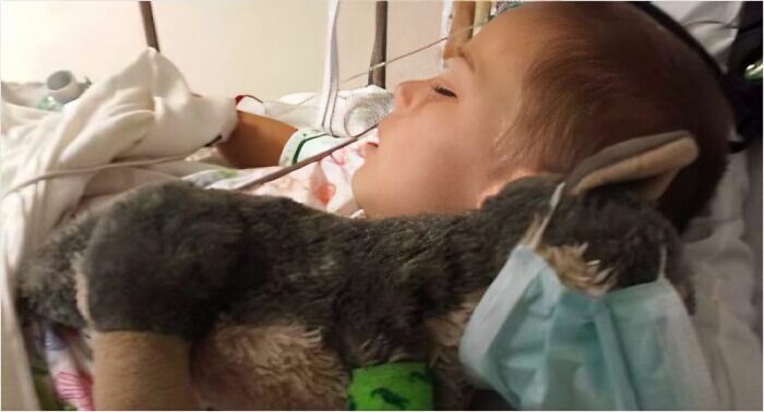 A young child asleep in a hospital bed, clutching a stuffed animal, embodying doctors' awesome sense of humor.