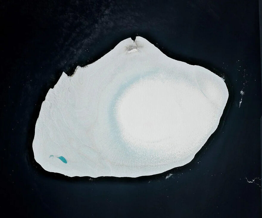 An aerial view of a remote, ice-covered landmass in dark water, highlighting one of the most isolated places on Earth.