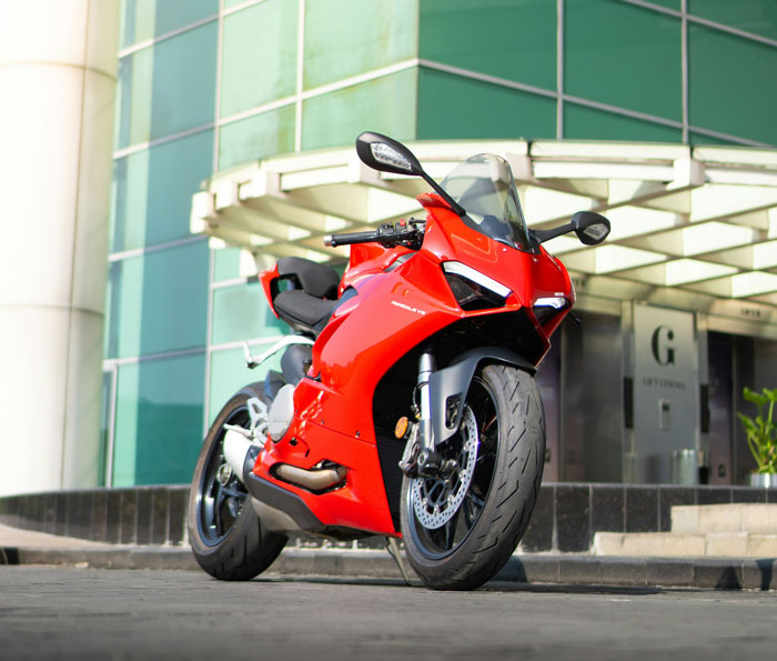 Red sport motorcycle parked in front of modern building