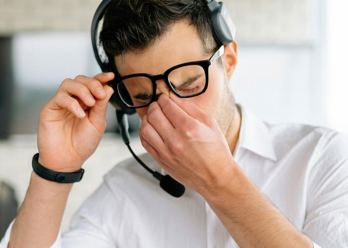 Man with headset frustrated by minor inconvenience at work