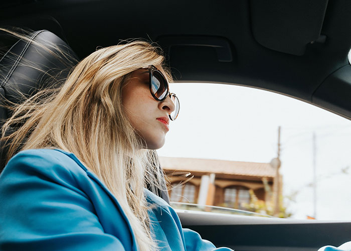 Woman wearing sunglasses driving car, illustrating mysterious vanishings