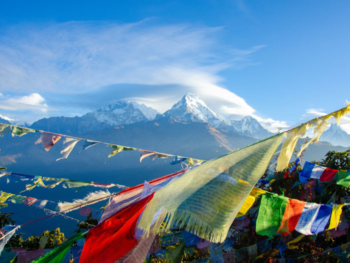 Colorful prayer flags fluttering with snowy mountains in the background