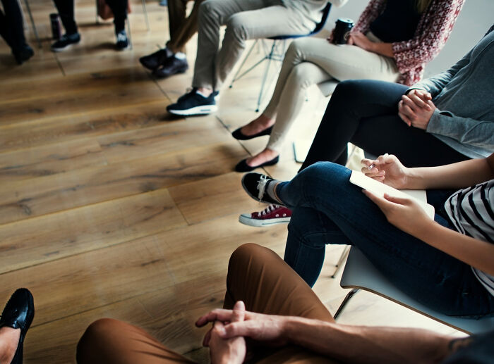 Group therapy session in psychiatric facility with patients seated