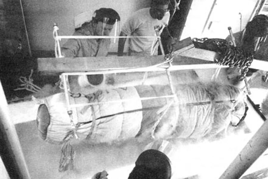 Historic black and white photo of medical staff preparing a large experimental apparatus