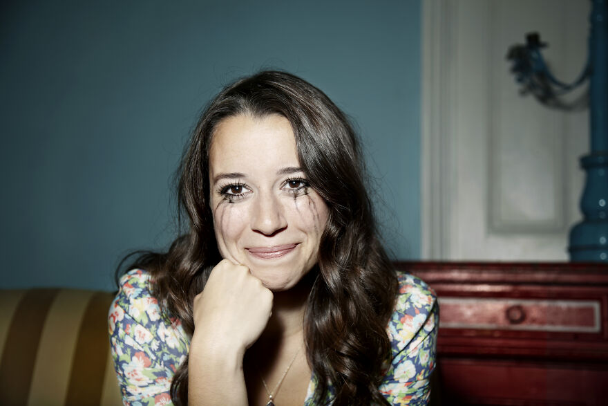 Woman with tear-streaked makeup smiling, showing emotional mood boost