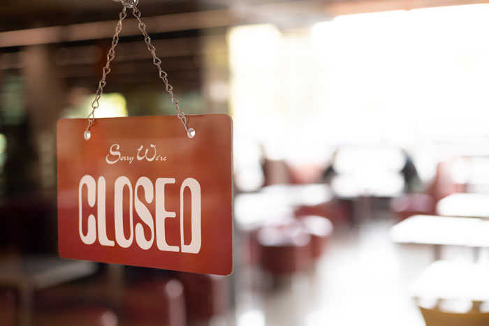 Closed sign hanging on a glass door in Europe