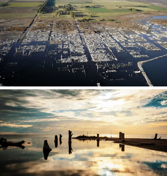 Aerial view of a flooded ghost town reclaimed by nature with submerged buildings and surrounding greenery
