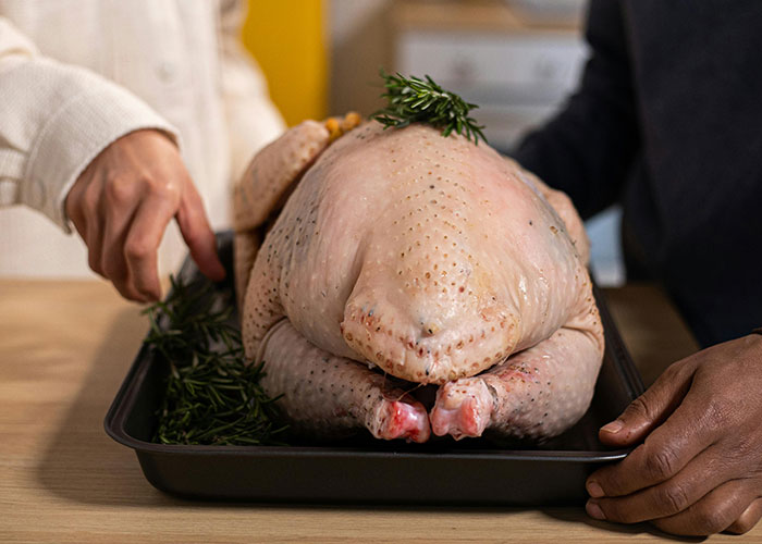 Raw turkey being prepared with herbs minor inconvenience emergency