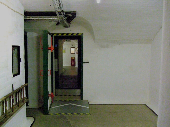 Empty white industrial room with a large heavy door open