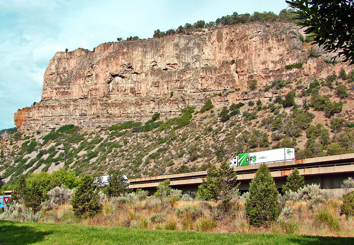 Truck driving on narrow mountain road with steep cliff, showing terrifying roads for truckers