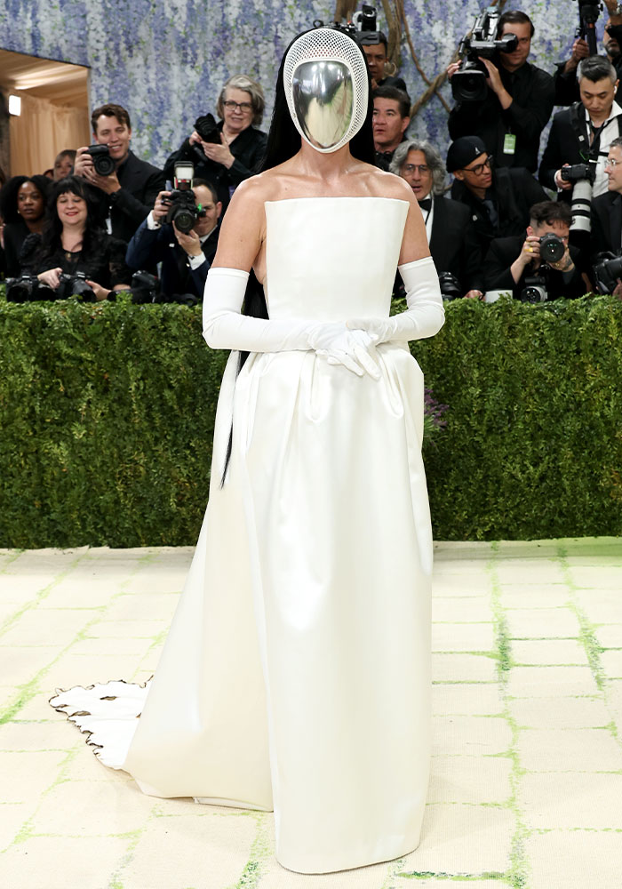 A Met Gala 2026 attendee in a white gown and metallic face mask, possibly one of the worst dressed stars.