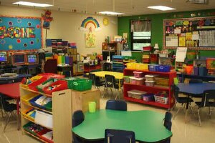 Colorful kindergarten classroom with small tables and educational decor