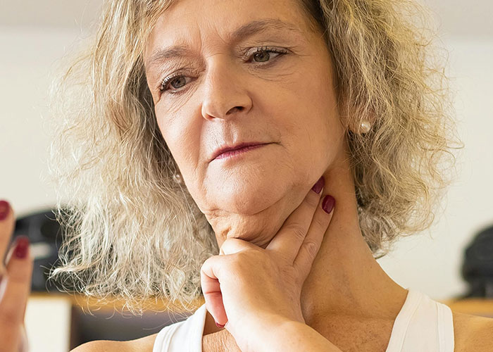 Woman holding throat showing discomfort in minor inconvenience emergency