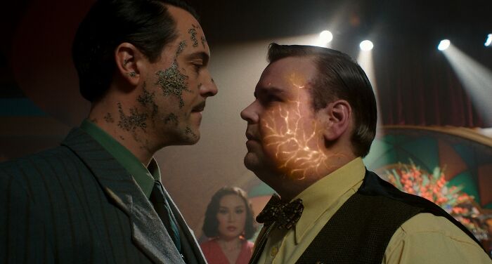 Two men facing each other with glowing facial effects in Spider-Noir series scene Two men facing each other with glowing facial effects in Spider-Noir series scene
