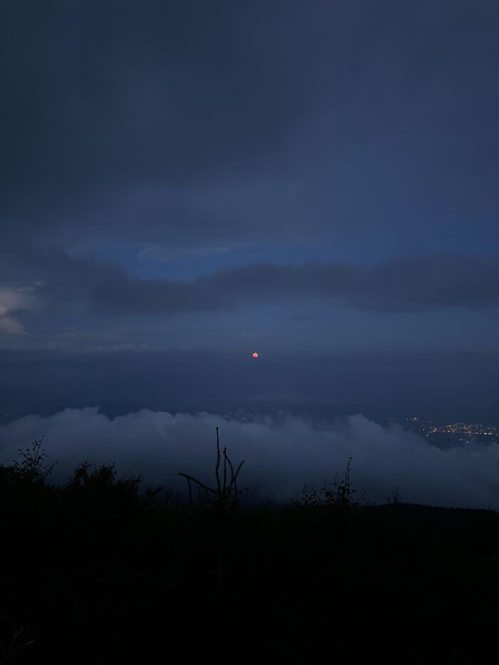 Red moon rising over cityscape at night rare moments photo