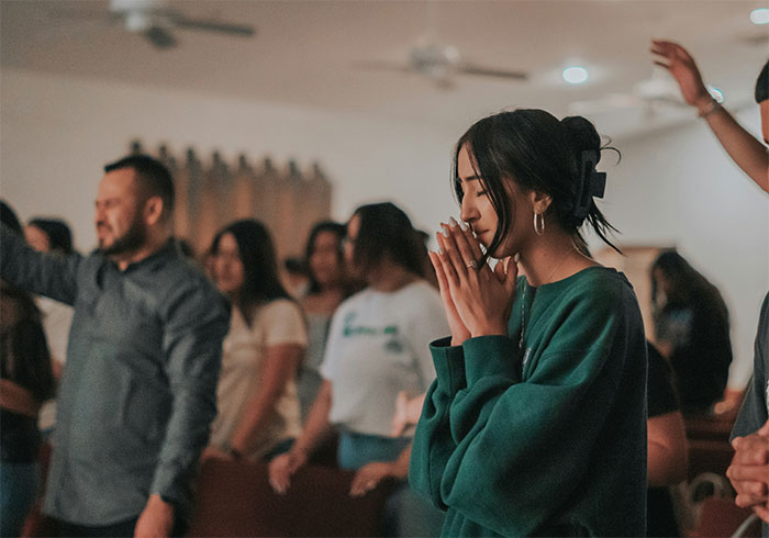 Young woman praying in an extremely restrictive religious community setting
