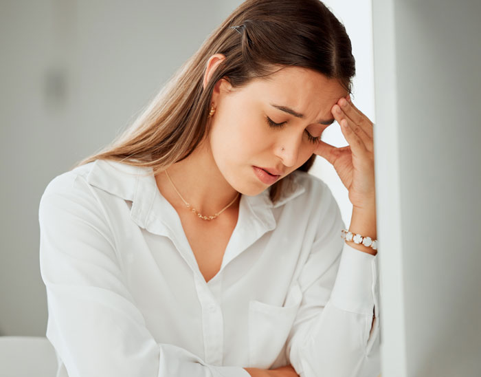 Stressed woman with headache reflects on her painful relationship