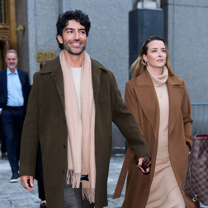Justin Baldoni and a woman, holding hands, in warm coats. They are involved in a multimillion-dollar case.