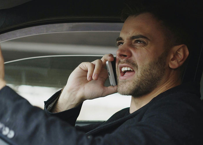 A frustrated man in a car, yelling into his phone. Could this be a sign of low intelligence or bad decision-making?