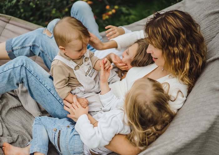 A happy mother with three young children relaxing in a hammock, avoiding very wrong facts on Reddit.