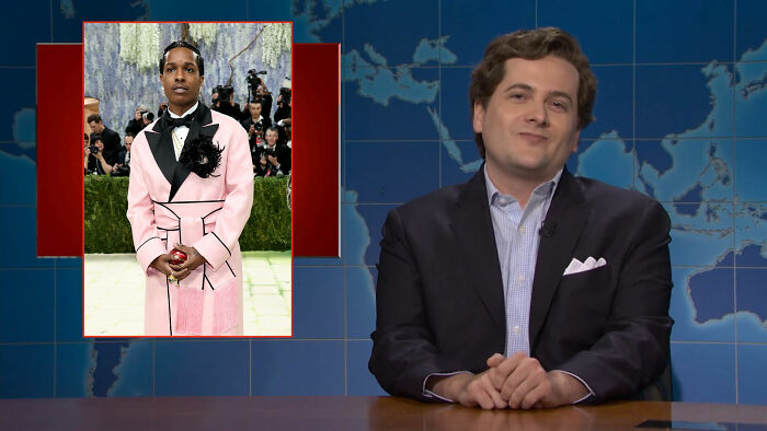 A news anchor with a world map behind him and a cutout of A$AP Rocky's Met Gala outfit, evoking the Statue of Liberty. A news anchor with a world map behind him and a cutout of A$AP Rocky's Met Gala outfit, evoking the Statue of Liberty.