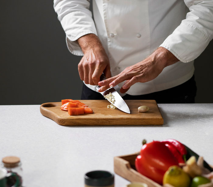 Chef chopping ingredients on cutting board for artisanal cooking