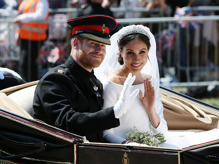 Prince Harry and Meghan Markle waving from carriage during royal wedding procession