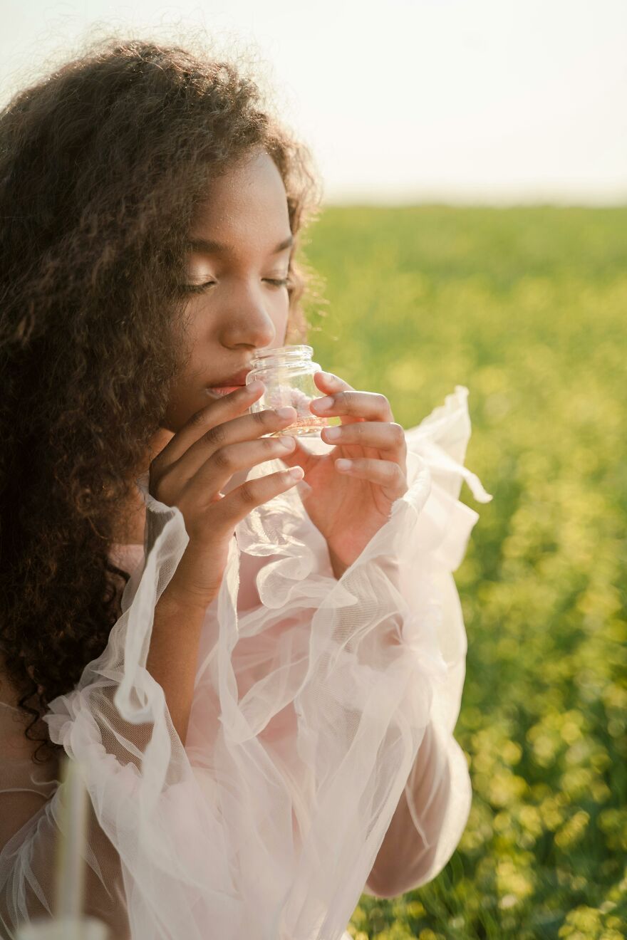 Woman smelling jar of scent for mood boosting effect