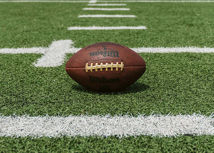 American football on green field emphasizing Super Bowl keyword American football on green field emphasizing Super Bowl keyword