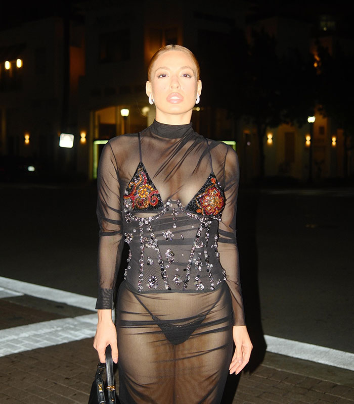 TV star posing in sheer outfit with beaded corset in Miami nighttime