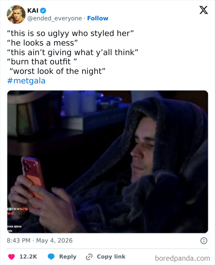 A person wrapped in a blanket, looking at their phone, representing funny reactions to Met Gala celebrity guests.