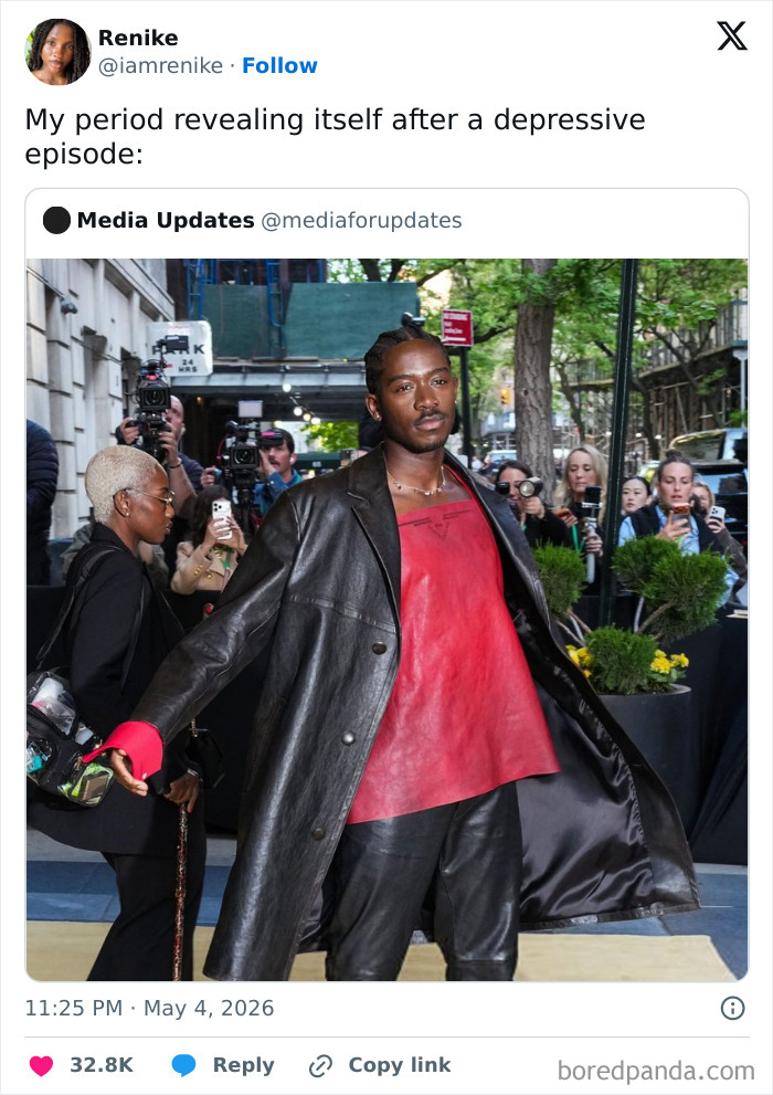 A celebrity guest, with braided hair, a black coat, and a red top, poses at the MET Gala 2026.