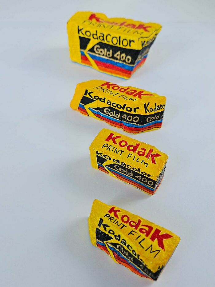Four colorful stone creations resembling Kodak film rolls on a white background, showcasing iconic foods and famous products.