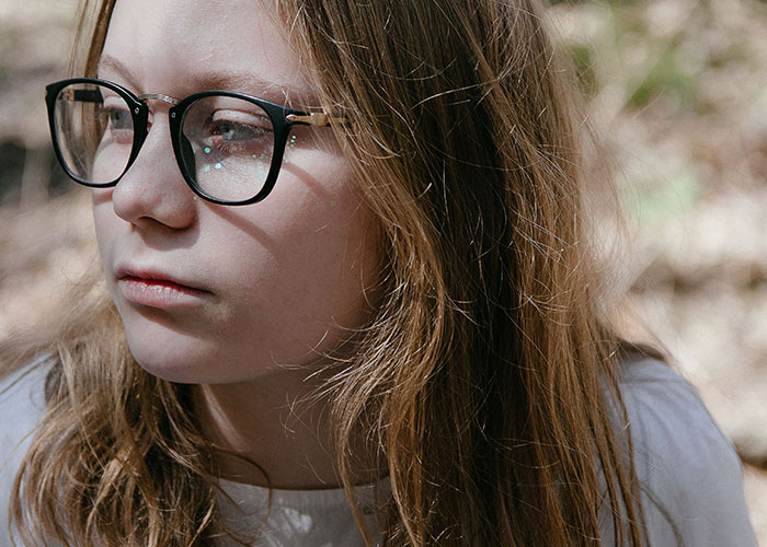 Closeup of thoughtful young person wearing glasses representing mysterious vanishings