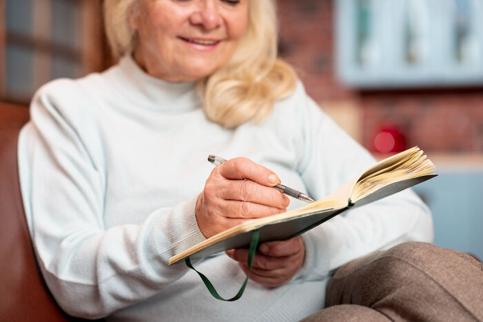 Elderly woman writing in a journal illustrating conspiracy theory moments explained by facts