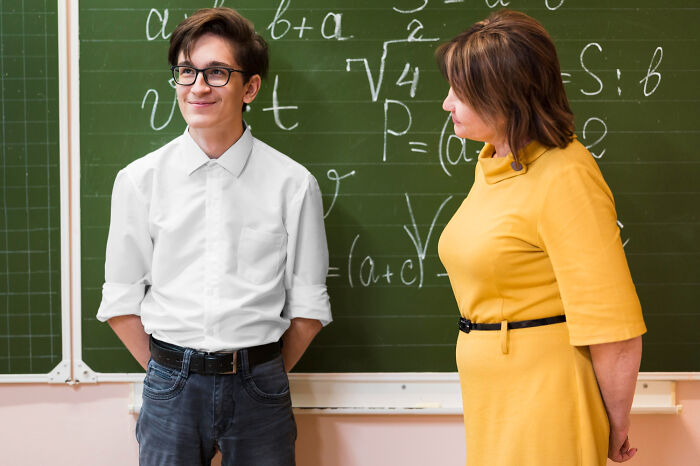 Student and teacher standing by chalkboard with math formulas