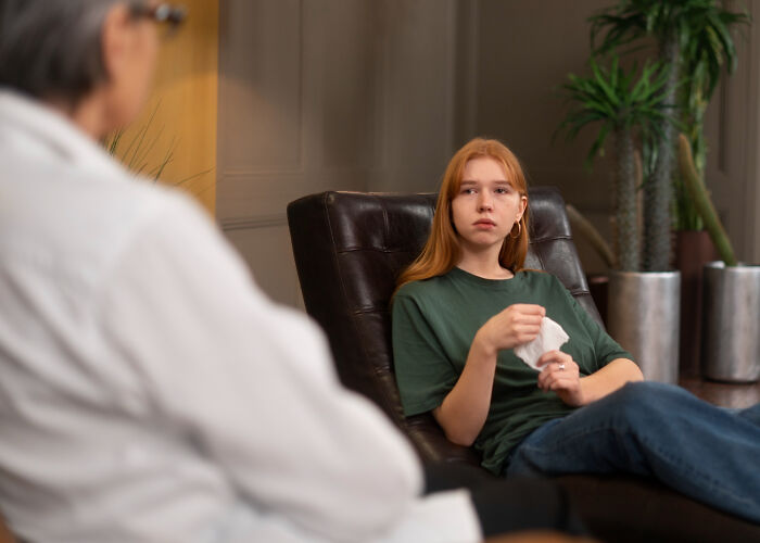 Young woman in therapy session discussing mental health at psychiatric facility