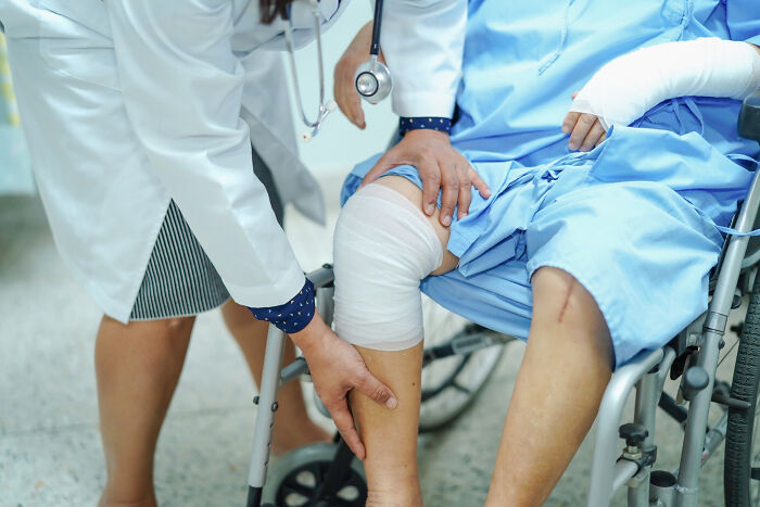 Doctor checking bandaged patient's leg in hospital January 6 care