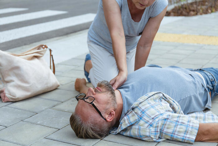 Man lying unconscious on sidewalk receiving emergency aid during January 6 event