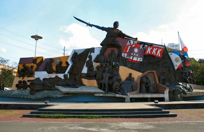 Filipino historical monument celebrating local heritage with K*K flags