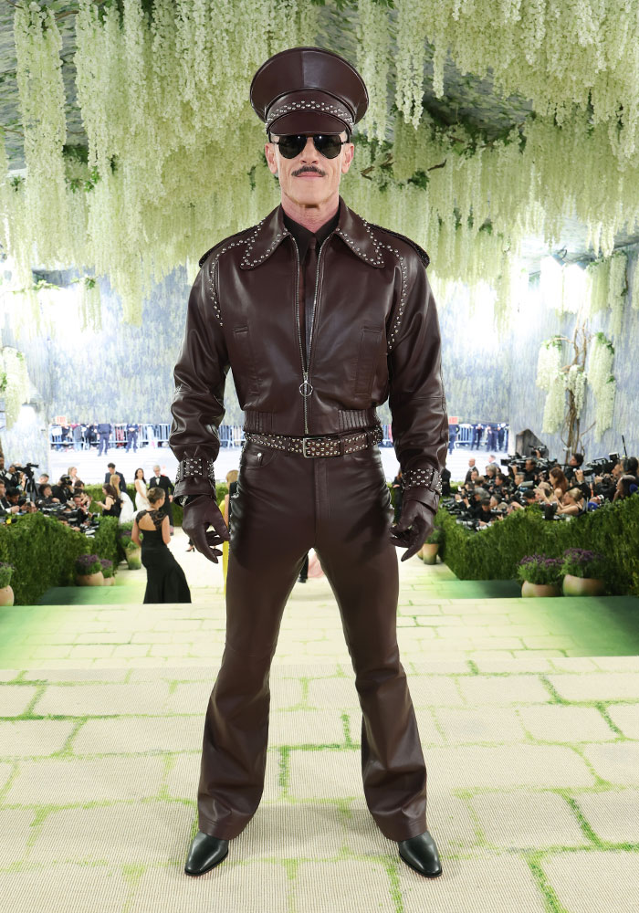 A man in a brown leather outfit, cap, and sunglasses at the Met Gala. Worst dressed stars.