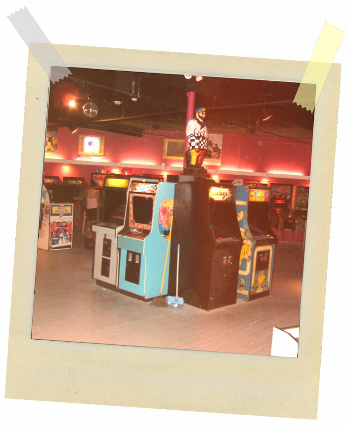 Vintage arcade machines in a dimly lit game room with a retro vibe