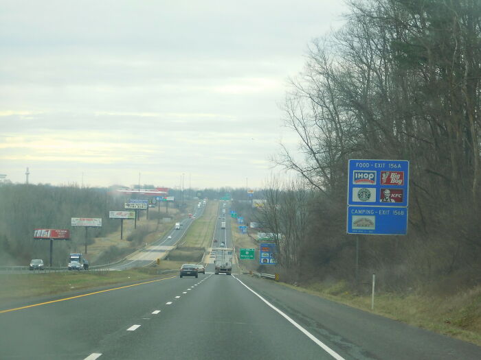 Busy highway with roadside signs and traffic, a common road truckers navigate