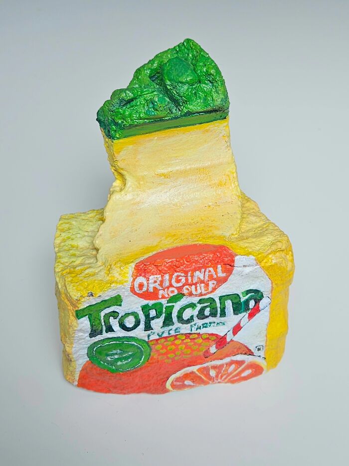A stone creation shaped like a Tropicana juice box. The artist transforms rocks into iconic foods and famous products.