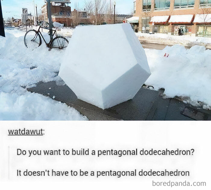 A perfectly shaped pentagonal dodecahedron snow sculpture on a sidewalk, next to a bicycle covered in snow. Funny math meme.