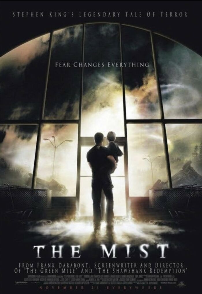 The Mist horror movie poster with a man holding a child inside a foggy store