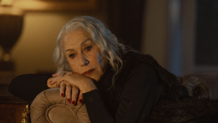 Older woman looking contemplative in dimly lit Mobland scene Older woman looking contemplative in dimly lit Mobland scene